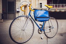 Charger l&#39;image dans la galerie, Sac messenger Dababo, modèle Transporter L2 avec option pour vélo. Attache poitrine à clips et attache cadre velo. Couleur bleu ciel sac attaché au cadre d&#39;un vélo.