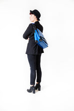 Charger l&#39;image dans la galerie, Sac bleu-classic messenger Dababo, modèle Transporter L avec option pour vélo. Porté par une femme dans le dos avec attache poitrine.