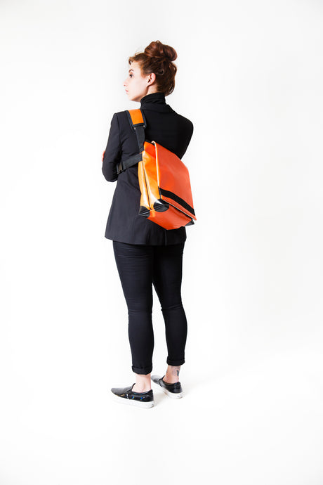 Sac messenger Dababo, modèle Transporter L avec option pour vélo. Porté par une femme dans le dos avec attache poitrine.