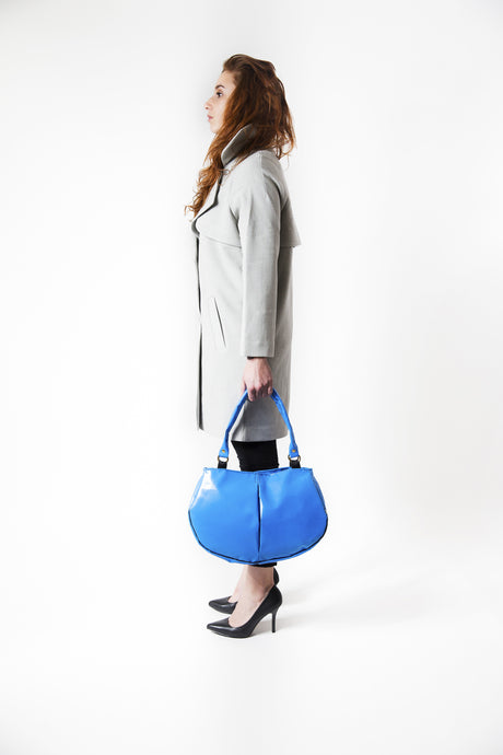Sac à mains de la marque Dababo, modèle Everyday en chutes de bache de camions recyclées avec anse. Modèle féminin porté de profil à la main