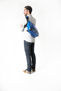 Sac messenger Dababo, modèle Transporter L2 avec option pour vélo. Attache poitrine à clips et attaches cadre velo. porté par un homme de profil. Couleur bleu clair.