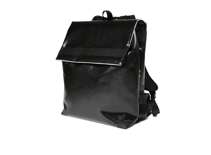 Sac à dos noir Tyrolien , marque Dababo en chutes de baches de camion recyclées. Grande contenance, fermeture par lien de serrage et rabat à Velcro. 